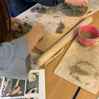 Children making clay lizards